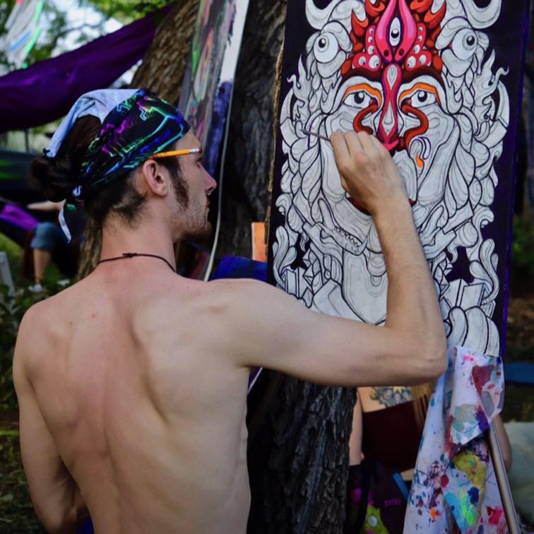 Ryan Lynch painting a detailed acrylic artwork outdoors.